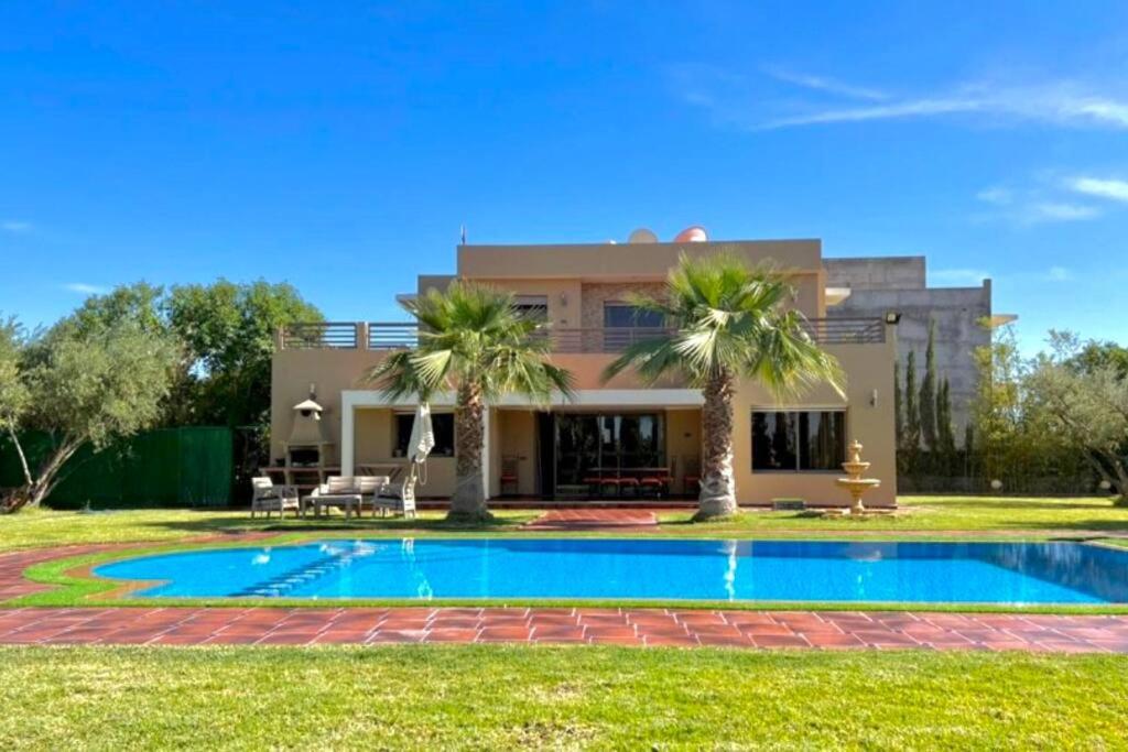 a house with a swimming pool in front of a house at Spacious Moroccan Private Villa With Heated Pool in Marrakesh