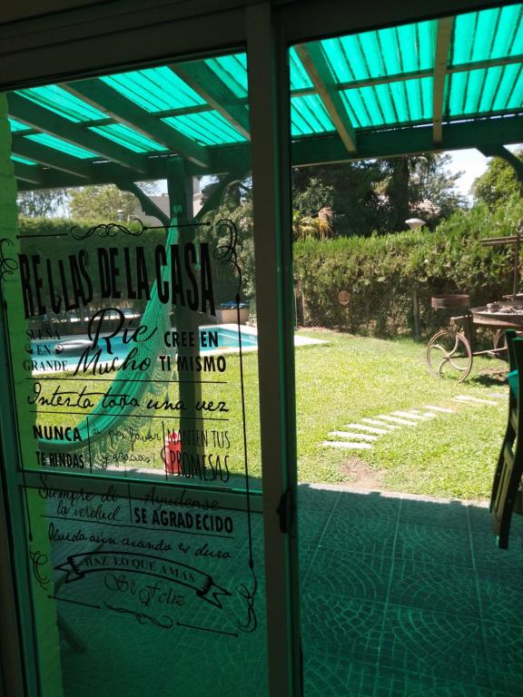 a glass door with a sign that reads holis beel cas casa pie at Habitación Dulce Descanso in Ezeiza