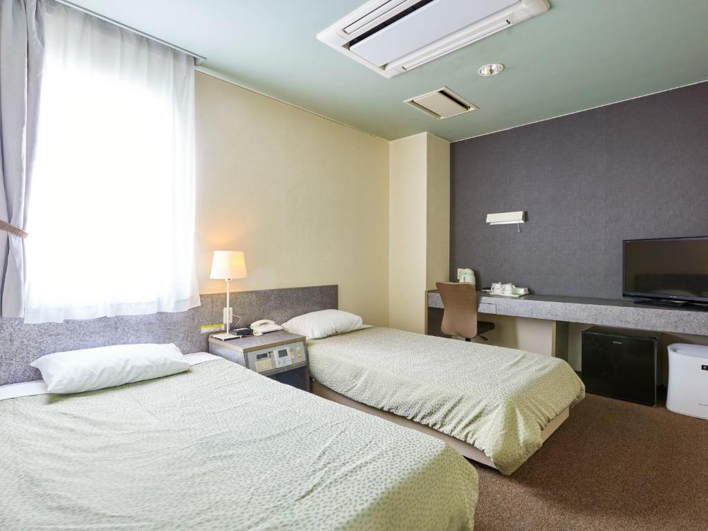 a hotel room with two beds and a television at Hotel Tsushima - Vacation STAY 84601v in Tsushima