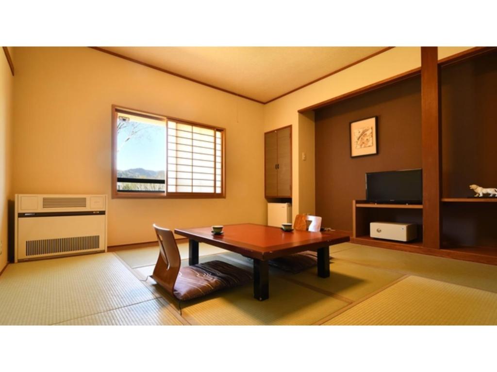 uma sala de estar com uma mesa e uma janela em Manzatei - Vacation STAY 27688v 