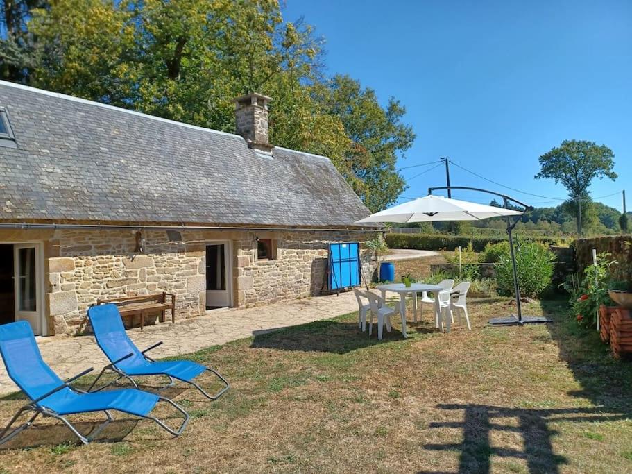 eine Terrasse mit Stühlen, einem Tisch und einem Gebäude in der Unterkunft Le Four de La Jugie in Le Lonzac