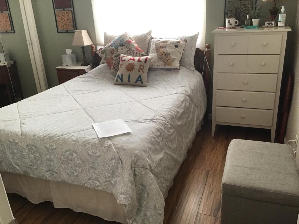 a bedroom with a bed with pillows and a dresser at Clovis, CA National Parks Room in Clovis