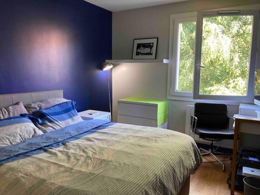 a bedroom with a bed and a desk and a window at Belle appartement T3 pour 5 personne max in Annecy