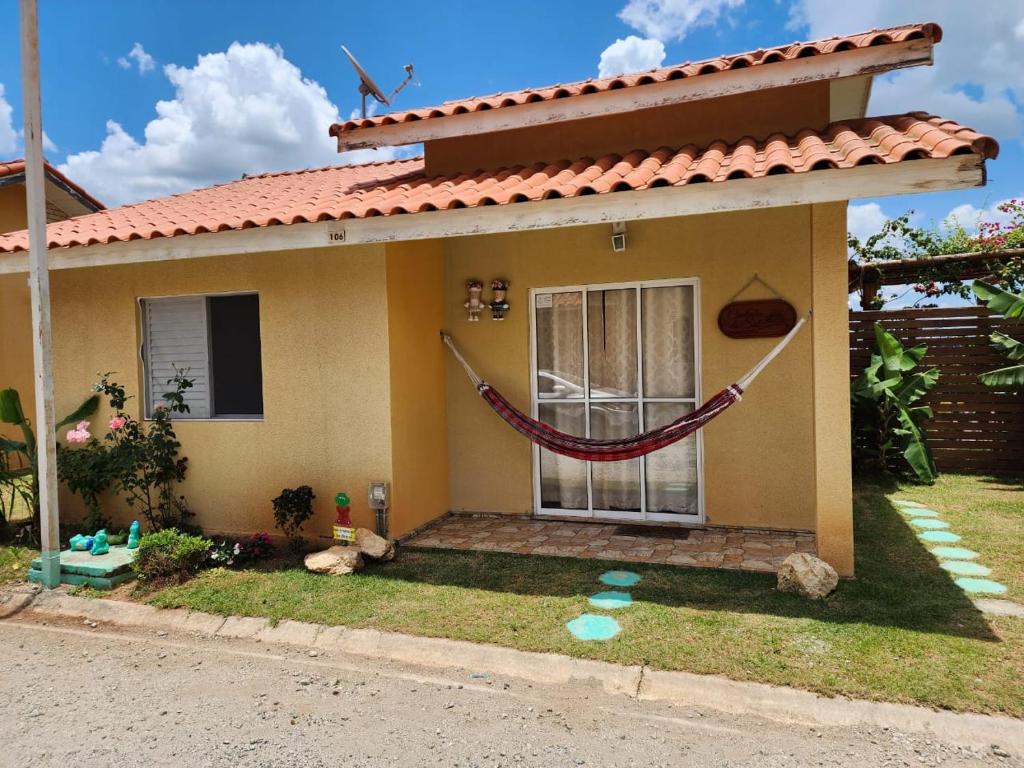 una casa con un'amaca di fronte di Chale Cantinho do Sol Catarina Home Club a Mairinque