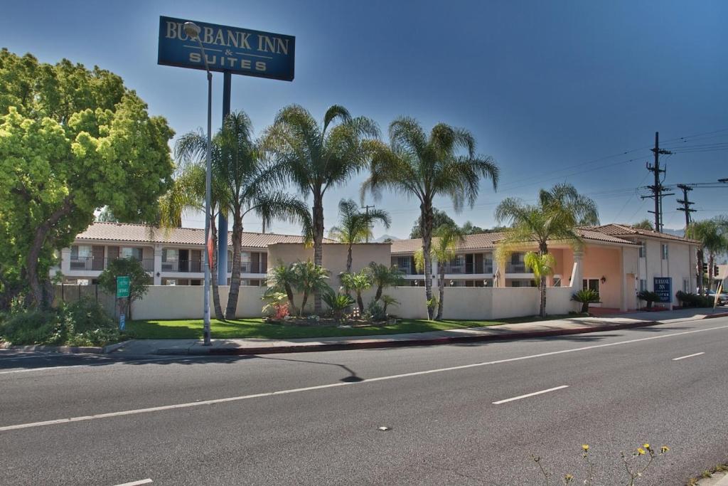 ein Straßenschild vor einem Gebäude mit Palmen in der Unterkunft Burbank Inn and Suites in Burbank