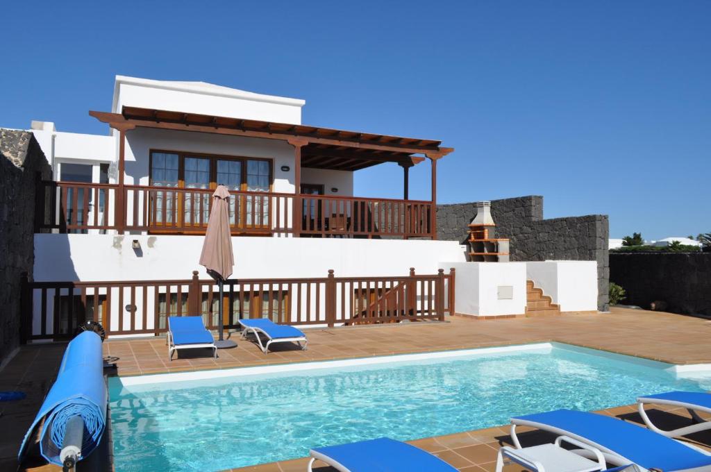 a villa with a swimming pool and a house at Villa Esmeralda in Playa Blanca