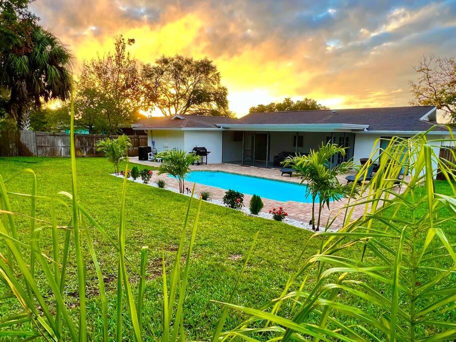 una casa con piscina en un patio en Heated Pool •honeymoon island• fireplace, en Palm Harbor