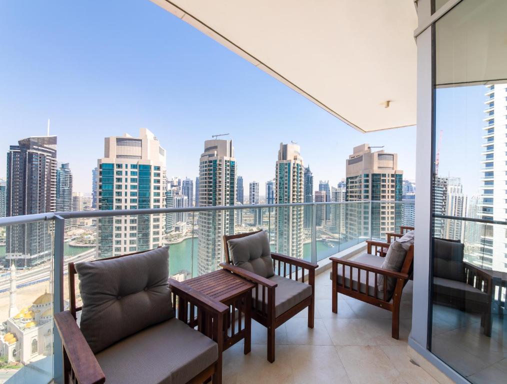 a balcony with chairs and a view of the city at Maison Privee - Spacious Apt with Beach, Pool and Marina Access in Dubai