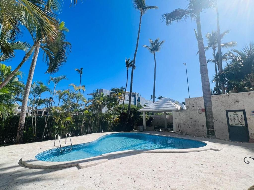 una piscina con palmeras en el fondo en Private Pool View 2BDR in Los Corales Punta Cana, en Punta Cana