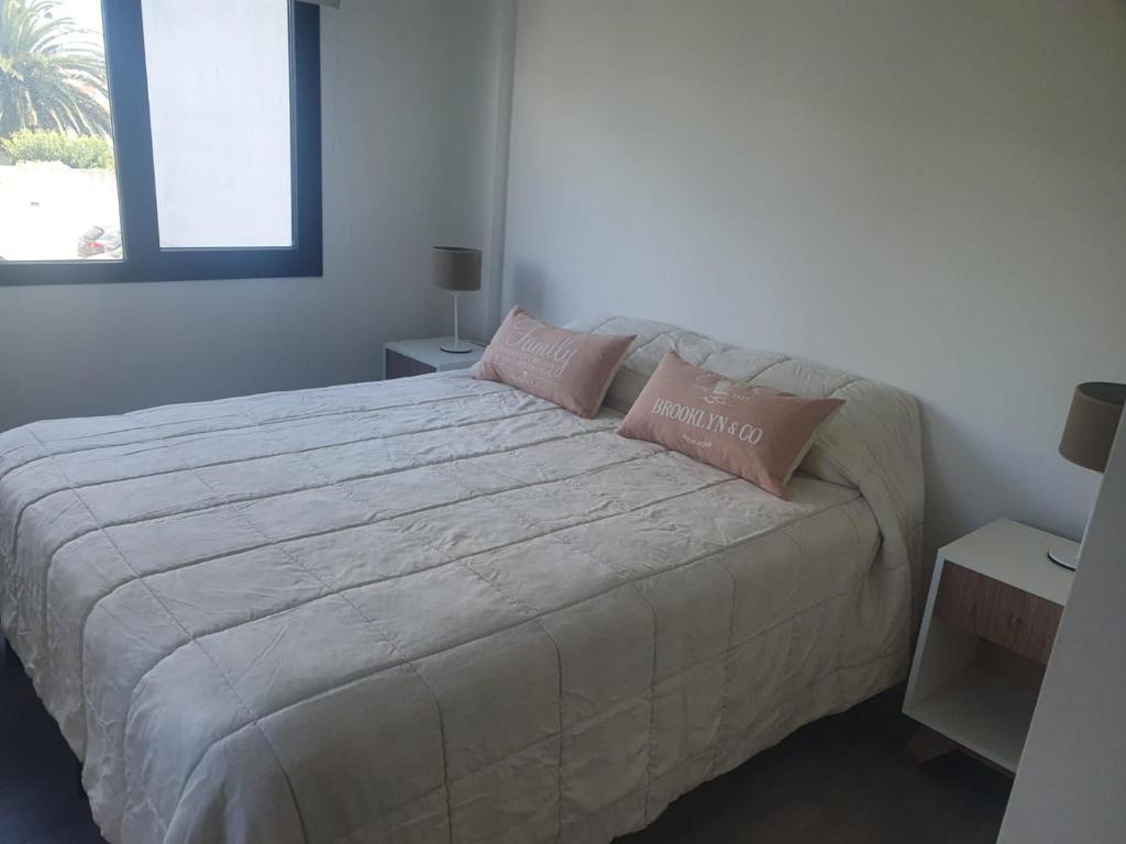 1 dormitorio con 1 cama grande y 2 almohadas en Alquiler FIDUS en Mar del Plata