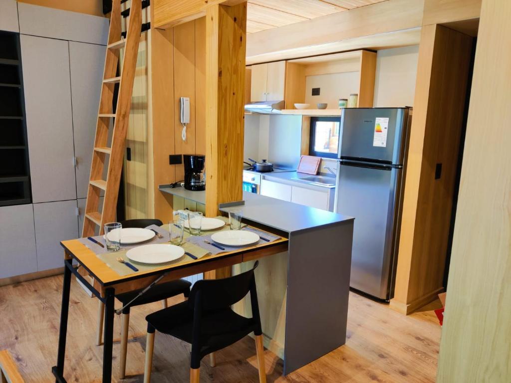 uma pequena cozinha com uma mesa e um frigorífico em Departamento dos ambientes, muy cálido y luminoso, en el centro de SMA. 17V5 em San Martín de los Andes