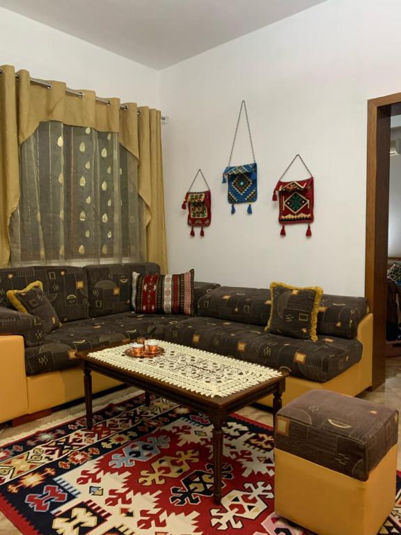ein Wohnzimmer mit einem Sofa und einem Tisch in der Unterkunft Vila Demaj in Berat