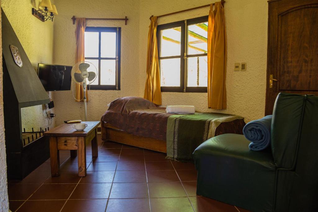 Bellamar Apart Hotel في بيلا فيستا: غرفة نوم بسرير وكرسي ونافذة