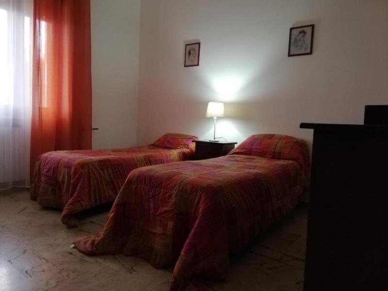 una camera con due letti e una lampada sul pavimento di Villino Schiavone a Racale