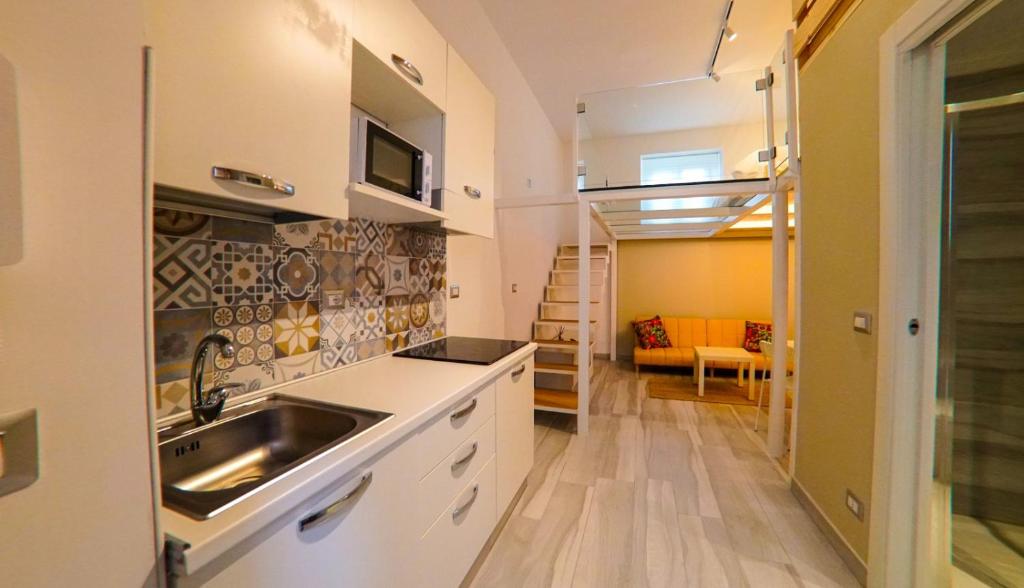 una cocina con armarios blancos y fregadero en Trescene Room Locazione Breve Turistica, en Benevento