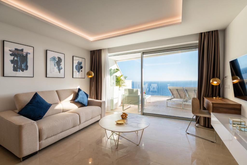 salon z kanapą i stołem w obiekcie Grand Horizon Luxury Boutique Apartments w mieście Puerto Rico de Gran Canaria