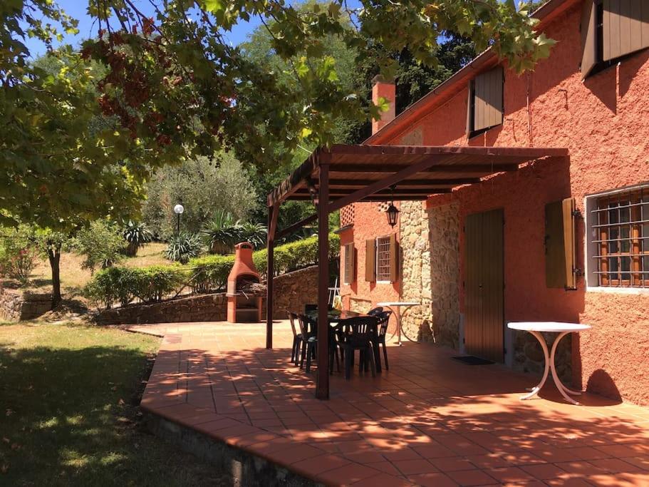 a patio with tables and chairs on a brick building at Podere La Cerraia in Serravalle Pistoiese