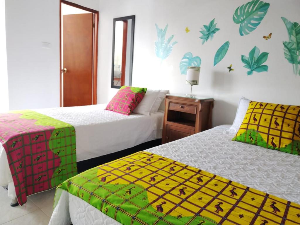 1 dormitorio con 2 camas con sábanas coloridas en Etnias Hotel tematico en Quibdó