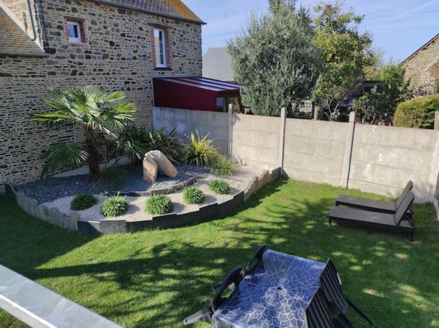 un jardin avec un banc et une clôture dans l'établissement Gîte Mont Saint Michel Beauvoir, à Beauvoir