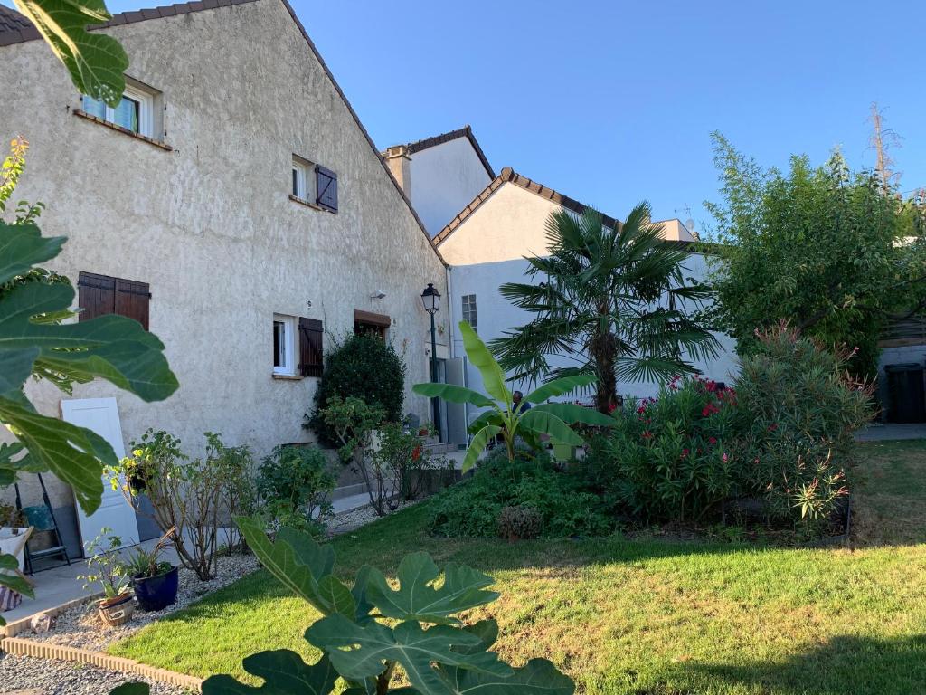 uma vista exterior de uma casa com um jardim em La maison parisienne & jardin em Argenteuil