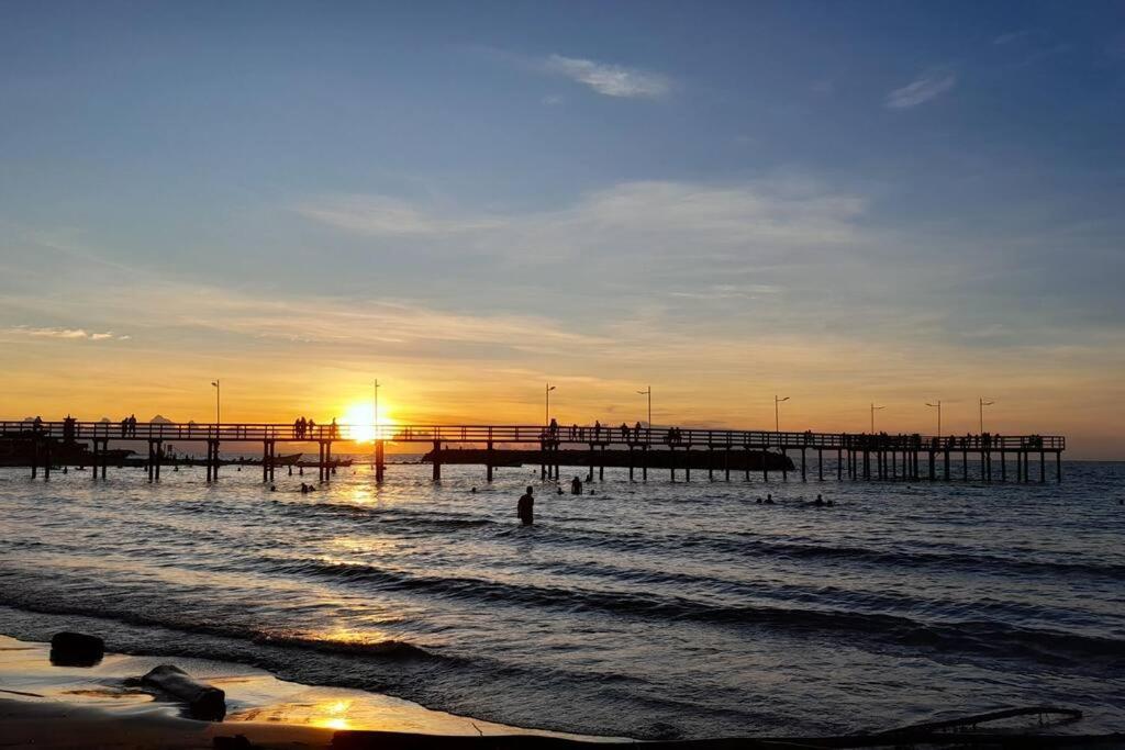 a pier in the ocean with people in the water at Apartamento Esmeralda Arboletes in Arboletes