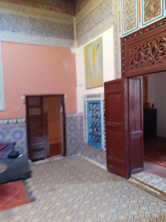 - un salon avec une porte en bois et un mur dans l'établissement Maison authentique centre médina, à Marrakech