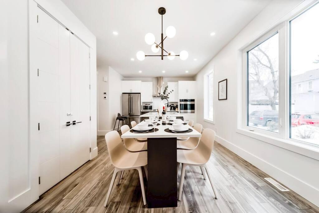 a white dining room with a table and chairs at Chic Retreat, 4BR Near DT & WEM, Fireplace, Trails, Sleeps 10! in Edmonton