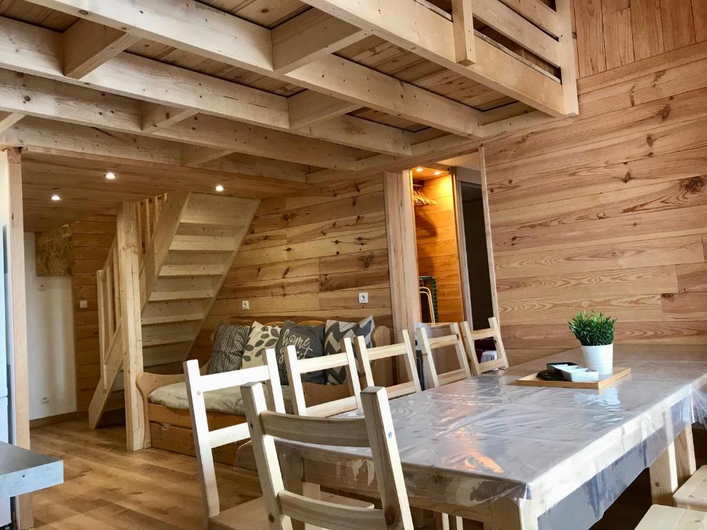 comedor con paredes de madera, mesa y sillas en appartement ski au pied, en Les Deux Alpes