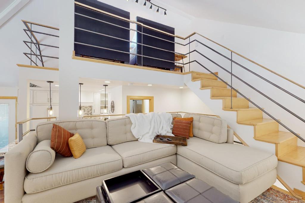 a living room with a couch and a staircase at Hidden Creek Retreat in Park City