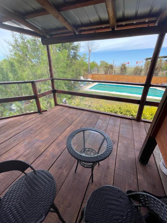 a deck with chairs and a table and a swimming pool at Altos de Kiyu in José Ignacio