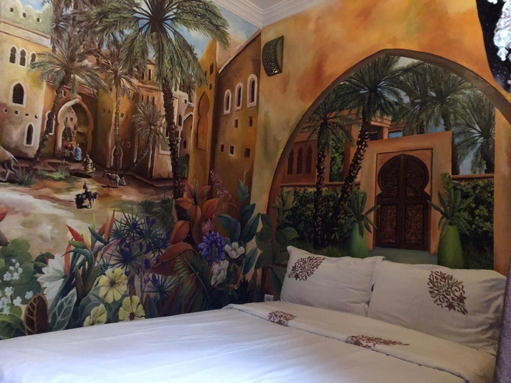 a bedroom with a painting on the wall at riad rose eternelle in Marrakesh