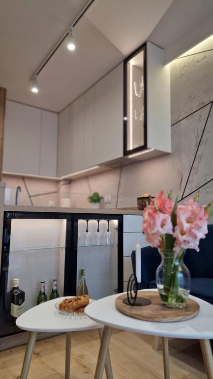 a kitchen with a table with a vase of flowers on it at Magic House Apartament Proszowska 58 in Bochnia