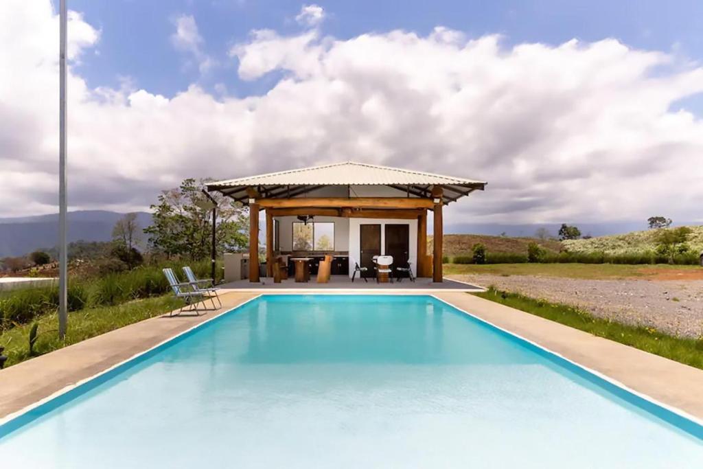 a swimming pool in front of a house with a gazebo at Rancho Bellavista, Unique views, Pool and WiFI! in Turrialba