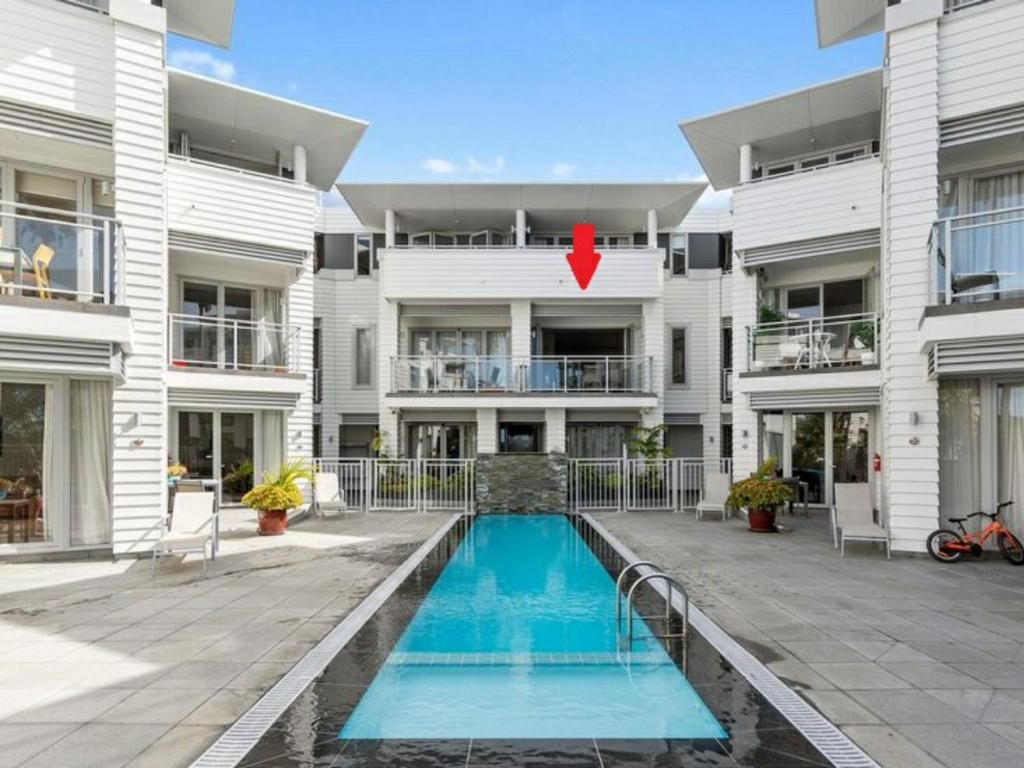 un bâtiment avec une piscine en face d'un bâtiment dans l'établissement The Waterfront - Paihia Holiday Apartment, à Paihia