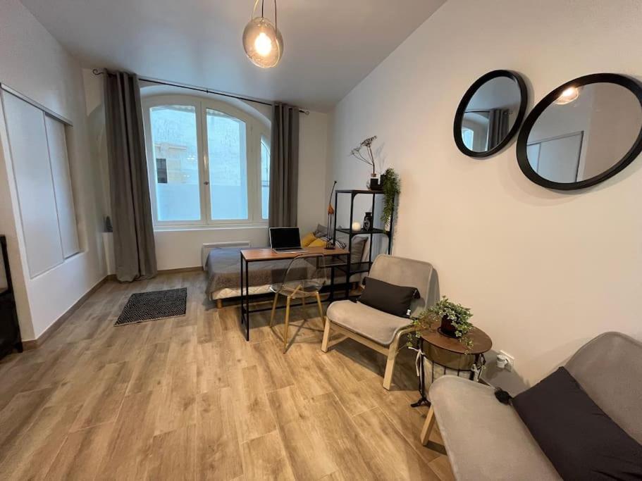 sala de estar con sofá, mesa y espejos en Studio cosy rez-de-chaussée, en Foix