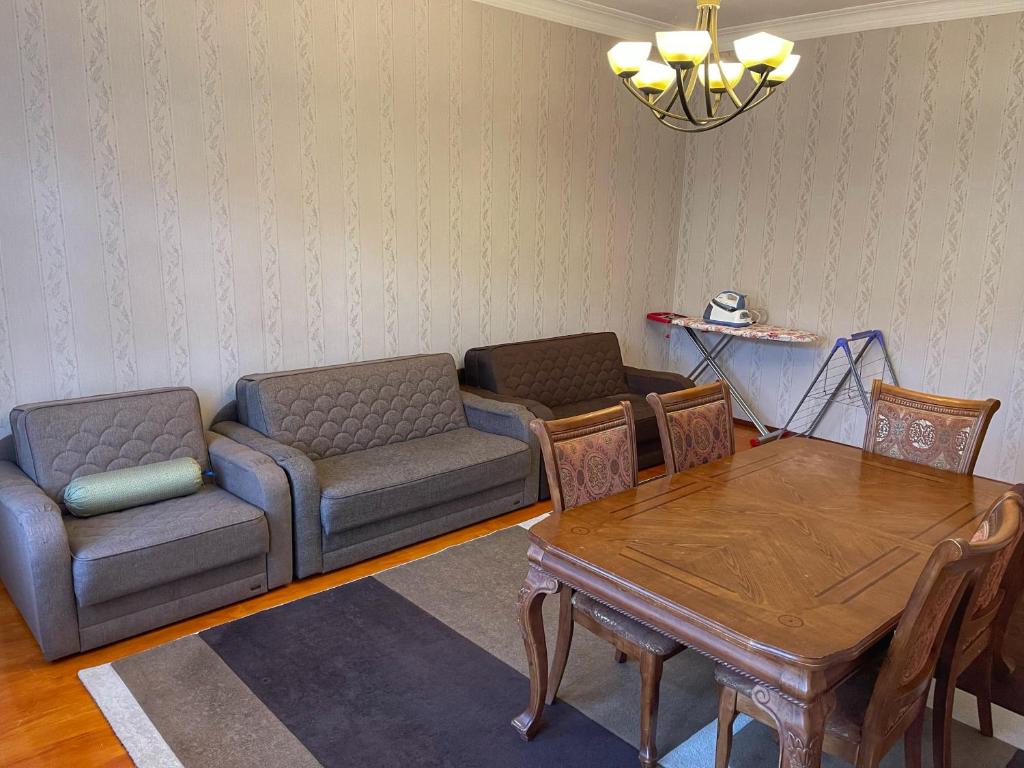 ein Wohnzimmer mit einem Sofa und einem Tisch in der Unterkunft Family Guest House in Qusar