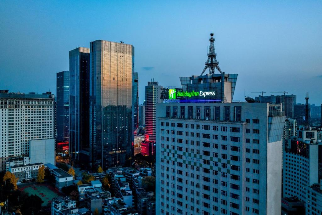 成都市にあるHoliday Inn Express Chengdu Tianfu Square by IHG - Chunxi Road and Kuanzhai Alleyの街中の、上に看板が掲げられた建物