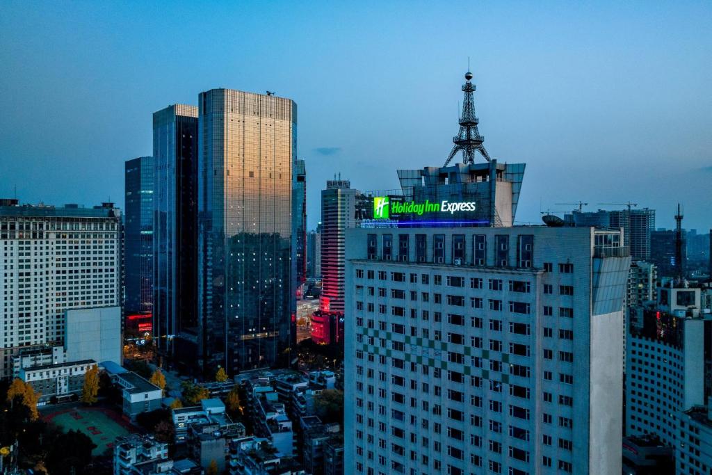 un bâtiment avec un panneau en haut dans une ville dans l'établissement Holiday Inn Express Chengdu Tianfu Square, an IHG Hotel - Chunxi Road and Taikoo Li, à Chengdu