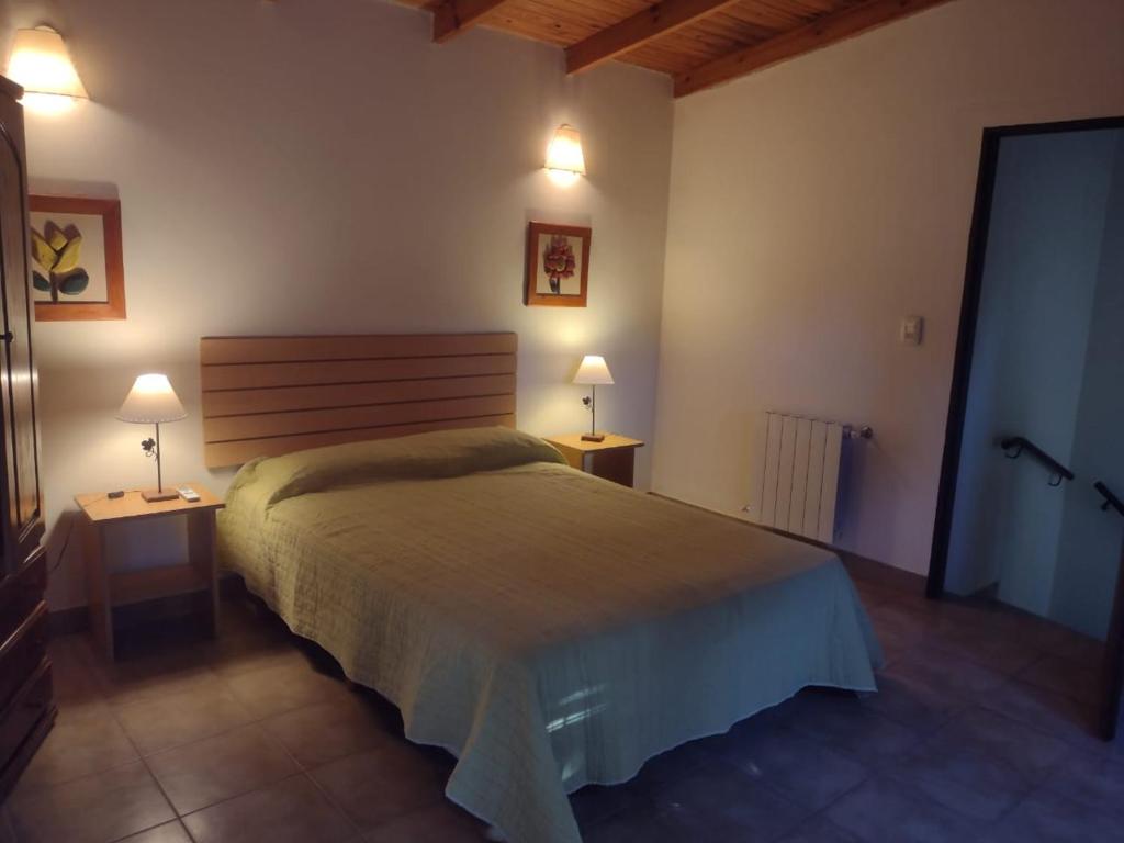 1 dormitorio con 1 cama y 2 lámparas en 2 mesas en Cabañas Los Cardales en Chascomús
