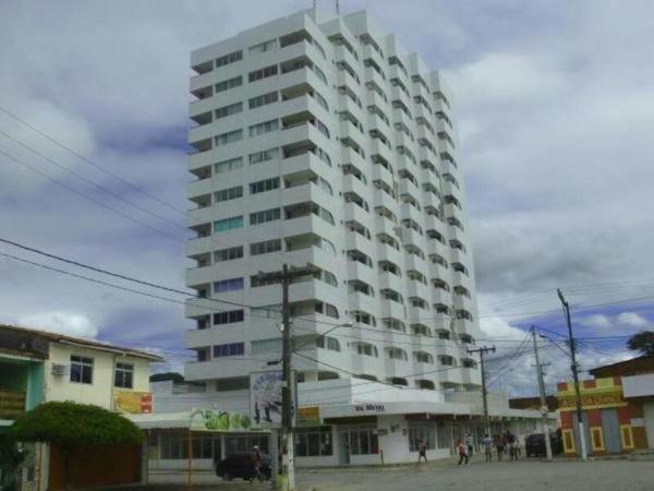 ein hohes weißes Gebäude auf einer Stadtstraße in der Unterkunft Flat com a melhor vista e localização da cidade! in São José da Coroa Grande