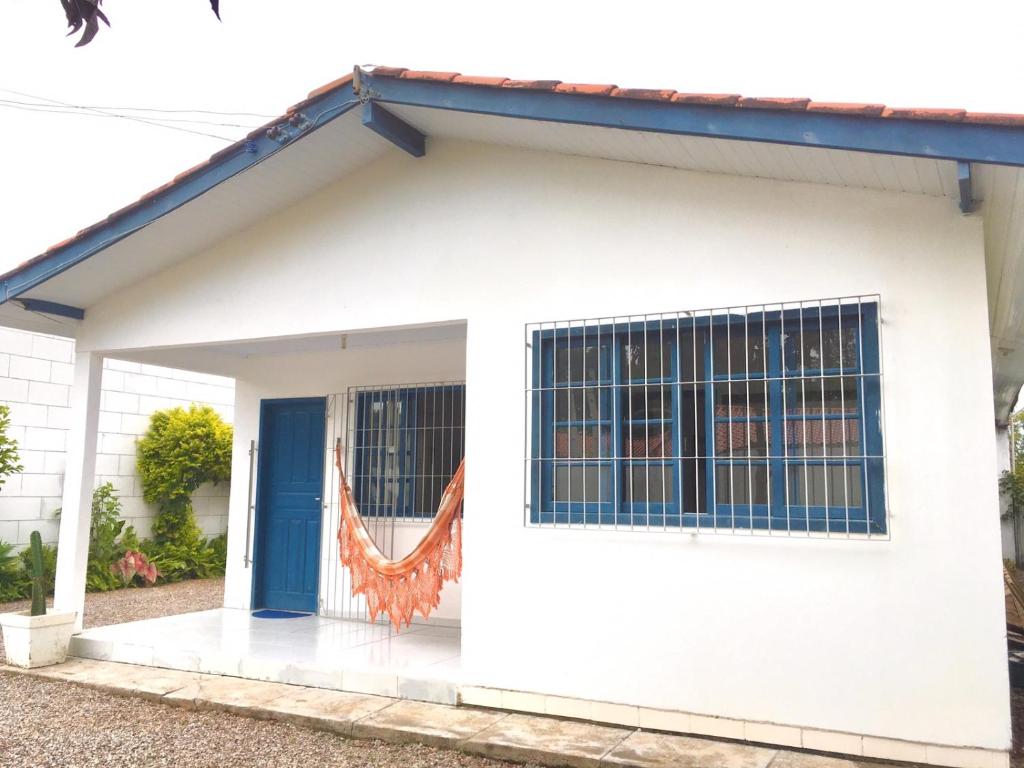 uma casa branca com uma porta azul em Morada Santa Pinheira em Palhoça