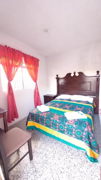 a bedroom with a bed and a window at Hotel Maya America in Panajachel