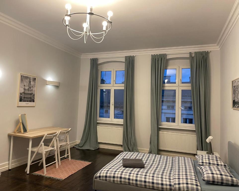 sypialnia z łóżkiem, biurkiem i oknami w obiekcie Spokojny Sen Quiet Rooms in Old Town w Poznaniu