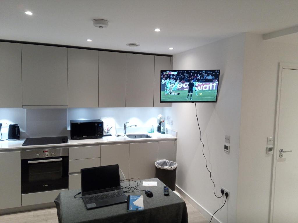a kitchen with a tv hanging on the wall at 23 floor studio for work 1Gb WiFi in Croydon