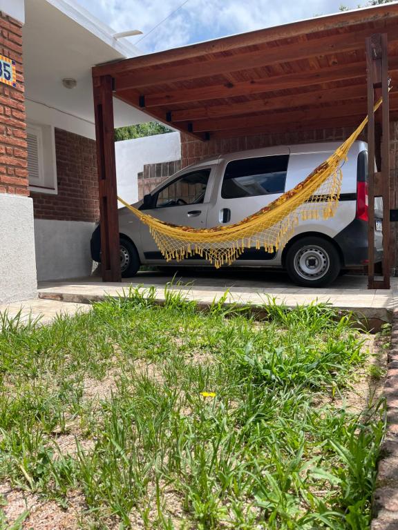 科斯金的住宿－Casa de Tati en Cosquín Córdoba，停泊在带吊床的停车场的汽车