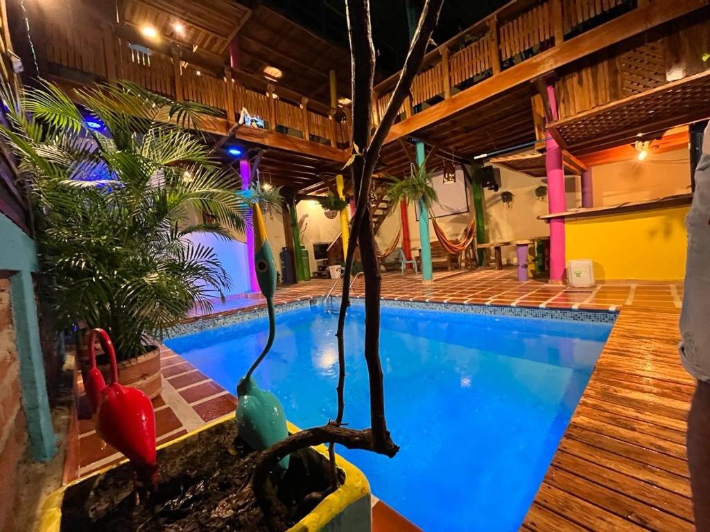 una piscina en un hotel con un árbol en el medio en El Refugio Minca, en Minca