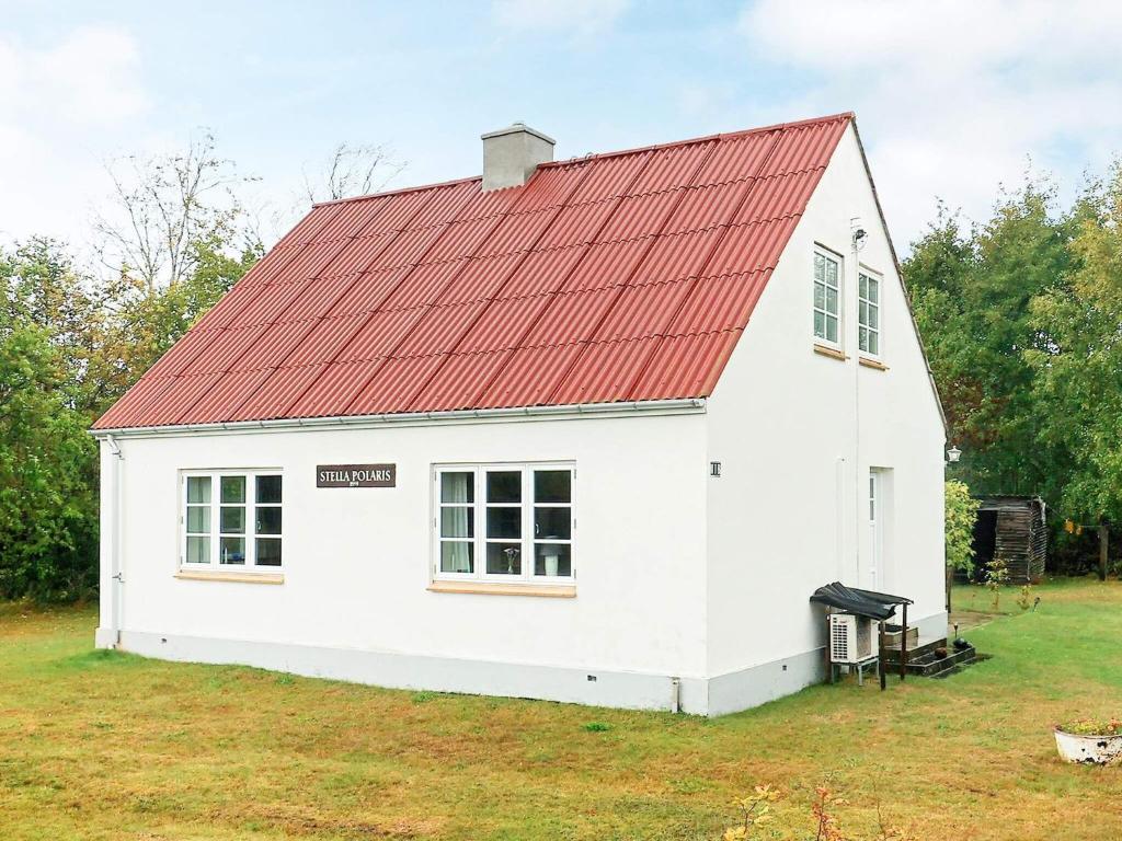 un granero blanco con techo rojo en Holiday home Læsø LIII, en Læsø