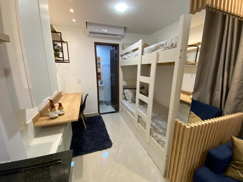 a room with bunk beds and a desk at Recanto Novo Premium Flat in Cabo Frio