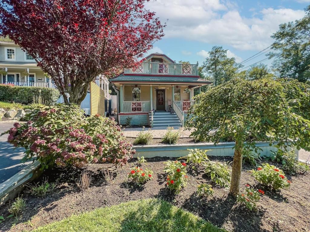 una casa amarilla con flores en el patio delantero en New Listing ! Captain's Cottage - Cold Spring Harbor Water Views, 