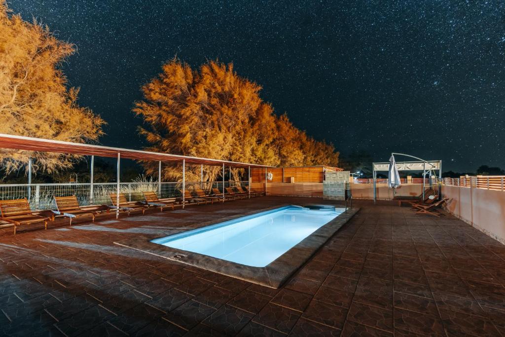 a swimming pool on a patio at night at Peumayen Atacama cabaña&Hostal in San Pedro de Atacama